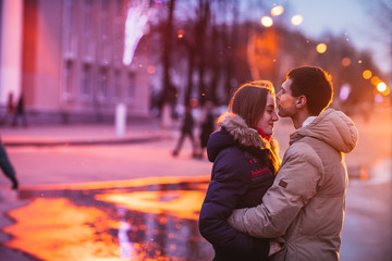 Portrait of young couple kissing in an autumn rainy day.