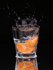 Slice of lemon splashing into a glass of water with