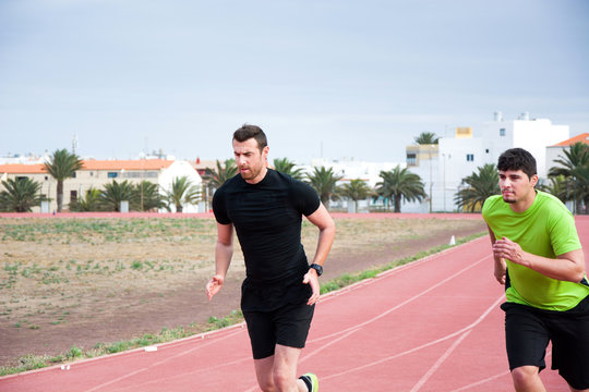 Two Men Running On Running Track