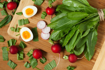 Healthy spring vegetables, sorrel, radish and eggs on wooden