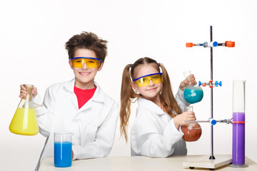 Two cute children at chemistry lesson making experiments