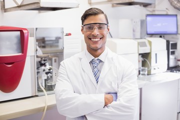 Smiling scientist looking at camera arms crossed