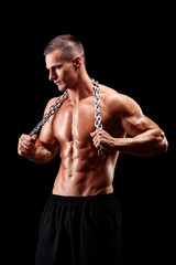 Shirtless young man holding a chain around his neck