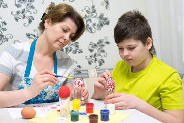 Obraz na płótnie Canvas Mom and son paint Easter eggs