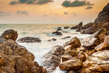 Fototapety  Seascape wybrzeże wieczornej fali ze skałą i chmurą na złotym niebie