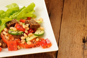 Vegetable salad with white beans, rye toasts, tomatoes, cucumber