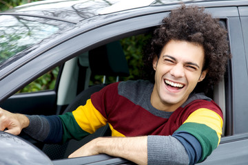Smiling handsome italian man sitting in car looking camera