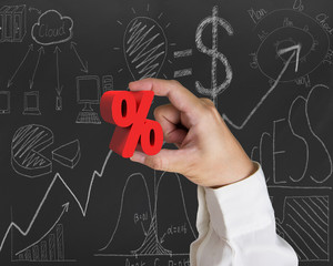 Hand holding 3D red percentage sign with business doodles blackb