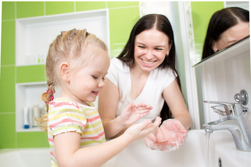 Obraz na płótnie Canvas kid girl washing hands with soap in bathroom