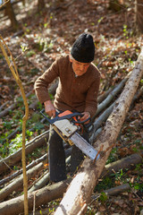 Old woodcutter at work with chainsaw