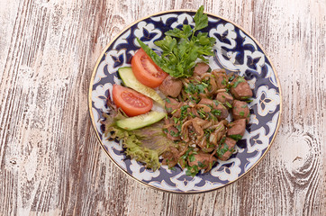 Fried meat with onion in a frying pan