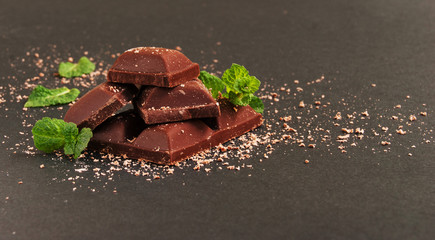 pieces of chocolate with mint lying on a wooden