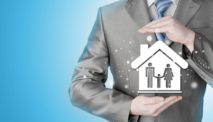 businessman protecting family in home with hands