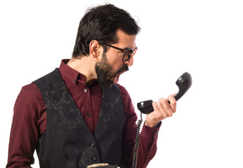 Naklejka premium Man wearing waistcoat talking to vintage phone