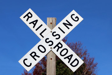 Railroad crossing sign against blue sky background - 81570687