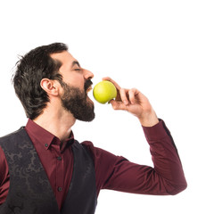 Man wearing waistcoat eating an apple