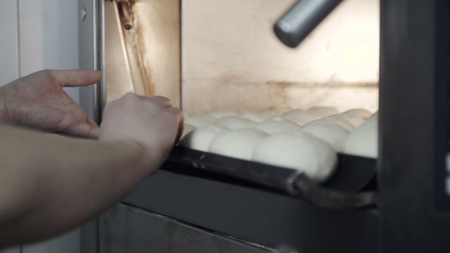 Chef put in the oven pan of biscuits extra close up