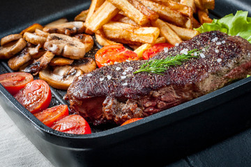 Fried steak with fries .