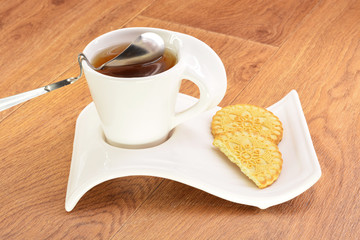 Black tea in a white mug and cookies