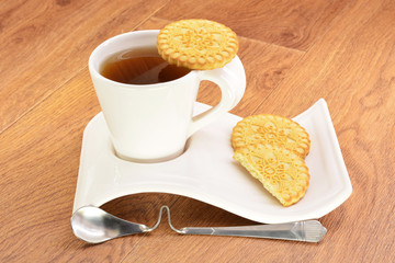 Black tea in a white mug and cookies