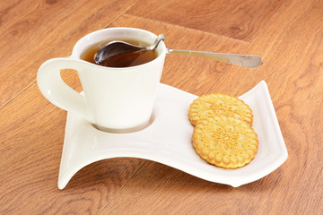 Black tea in a white mug and cookies