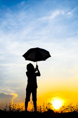 Motion blur jumping Umbrella girl with sunset silhouette