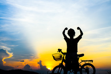Silhouette of the cyclist riding a road bike at sunset
