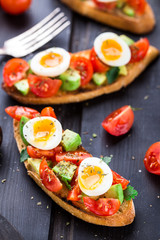 Bruschetta with tomato, avocado and quail egg