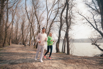 Young couple jogging in a park by the river