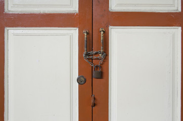 wooden door locked with chain and padlock.