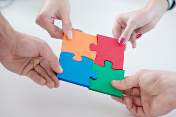 Group of business people assembled jigsaw puzzle and represent interpersonal cooperation and success