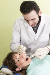 Fototapeta premium Unshaven dentist examines teeth woman smiling patients
