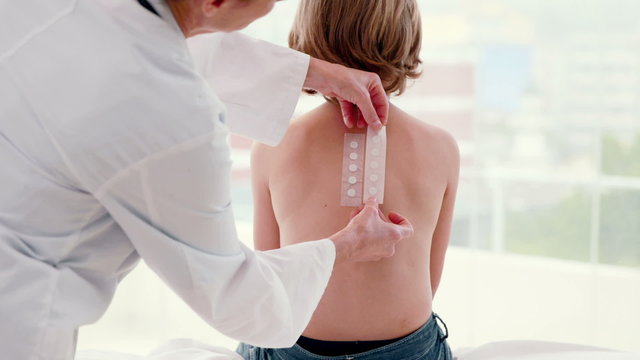 Doctor sticking patch test at her patient