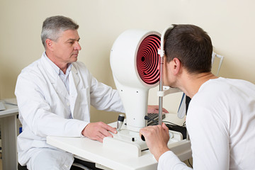 Man having his eyes examined by an eye elderly doctor.