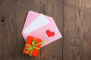 Love letter with gift on old wooden table