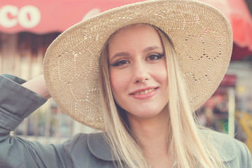 Portrait of attractive smiling blonde woman with straw hat.