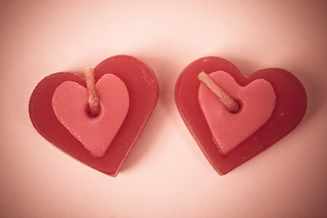 two red scented candles in shape of a heart on wood plank floor