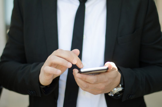 Uomo business utilizza cellulare