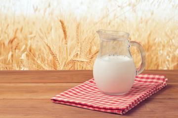 Milk jug over wheat field background