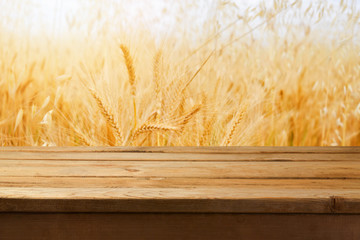 Empty wooden table over wheat field background © maglara
