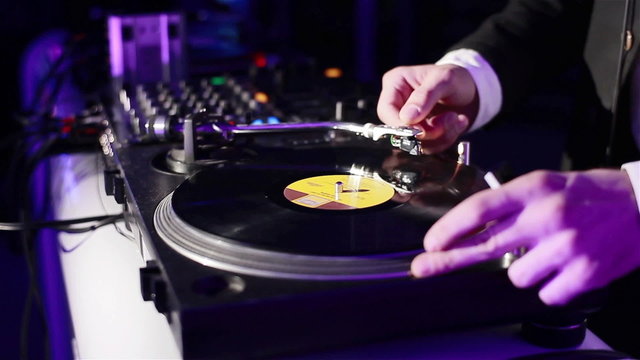 Dj spinning vinyl in a night club. Close-up
