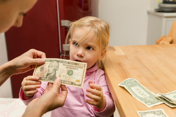 Mutter zeigt Kind Dollar Banknoten