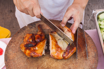 Chef are using Kitchen knife chicken grilled on wood block