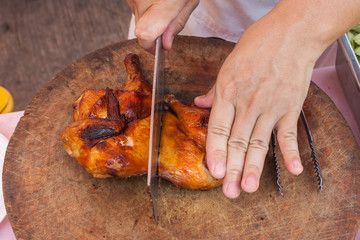 Chef are using Kitchen knife chicken grilled on wood block