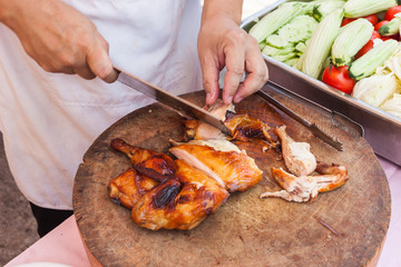 Chef are using Kitchen knife chicken grilled on wood block