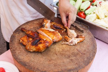Chef are using Kitchen knife chicken grilled on wood block