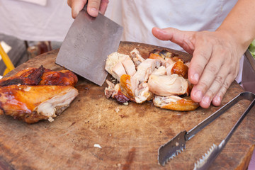 Chef are using Kitchen knife chicken grilled on wood block
