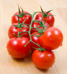 Tomatoes cherry branch on a wooden board