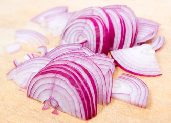 Cuts of red onion on a wooden board