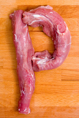 Letter P made from fresh meat on a wooden board - 81597204